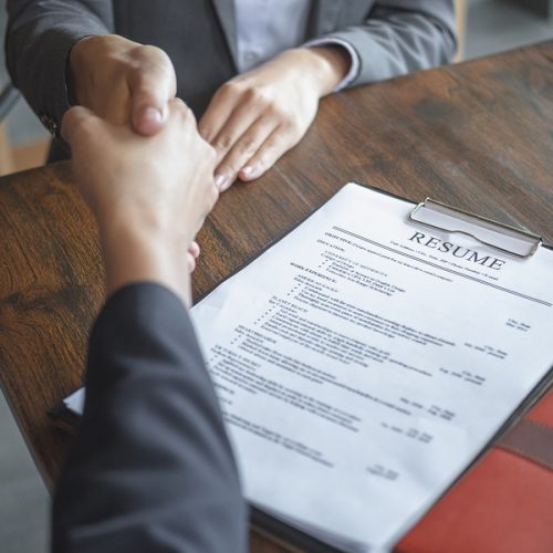 Handshake Success Job Interviewing. Job Applicant Having Intervi Handshake success job interviewing. Job applicant having interview. Shaking Hand With Resume On Desk. Employer giving an handshake to the candidate after the job interview.